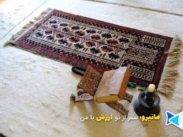 فضای عرفانی خانه‌ای ساده با قرآن و سجاده باز، نور آفتاب از پنجره داخل می‌تابد.